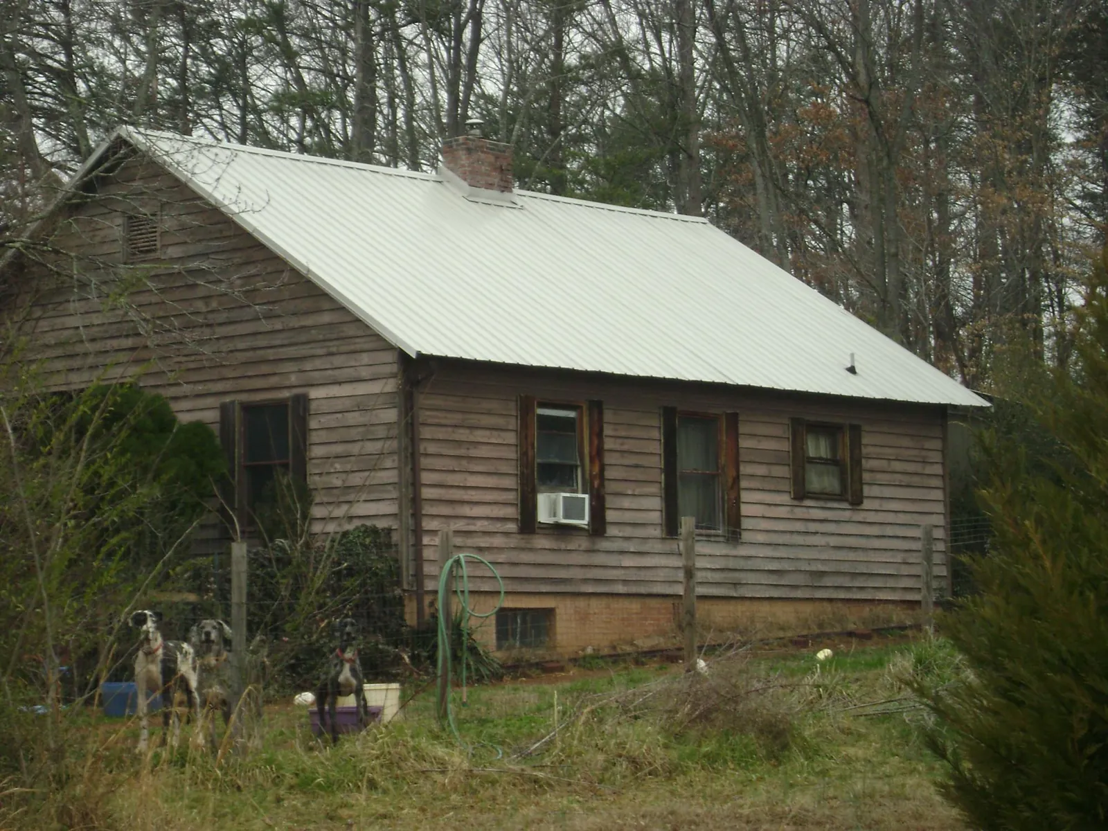 White metal roof on an old wood sided farmhouse, from a Metal Roof Installation job in Boonville